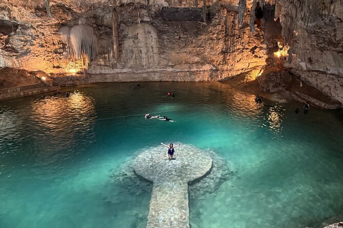 The circular stone platform in the middle of Cenote Suytún, lit by the shaft of light through the cave roof