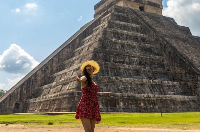 El Castillo seen across the main plaza at Chichén Itzá with a visitor in the foreground for scale