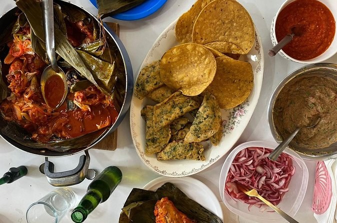 A Yucatecan table laid with a pot of stew, tortillas, salsas and pickled onion in small dishes